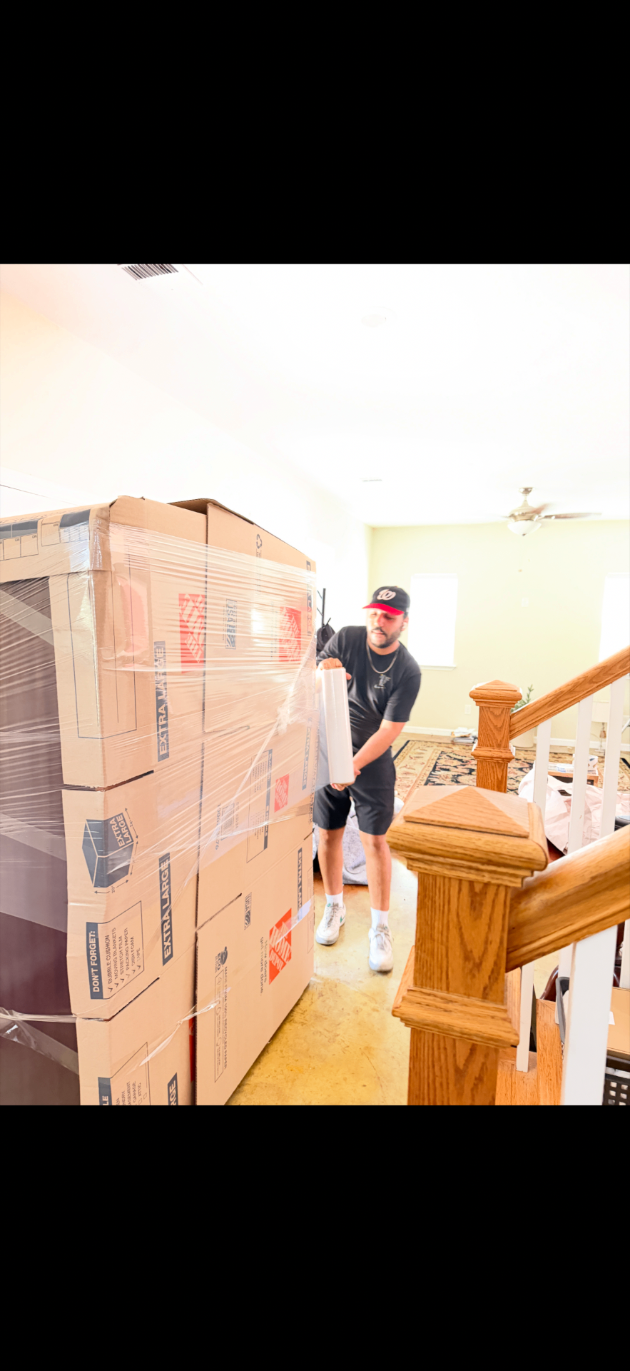 Kamal Dahaby wrapping a furniture piece in stretch film during an Austin move