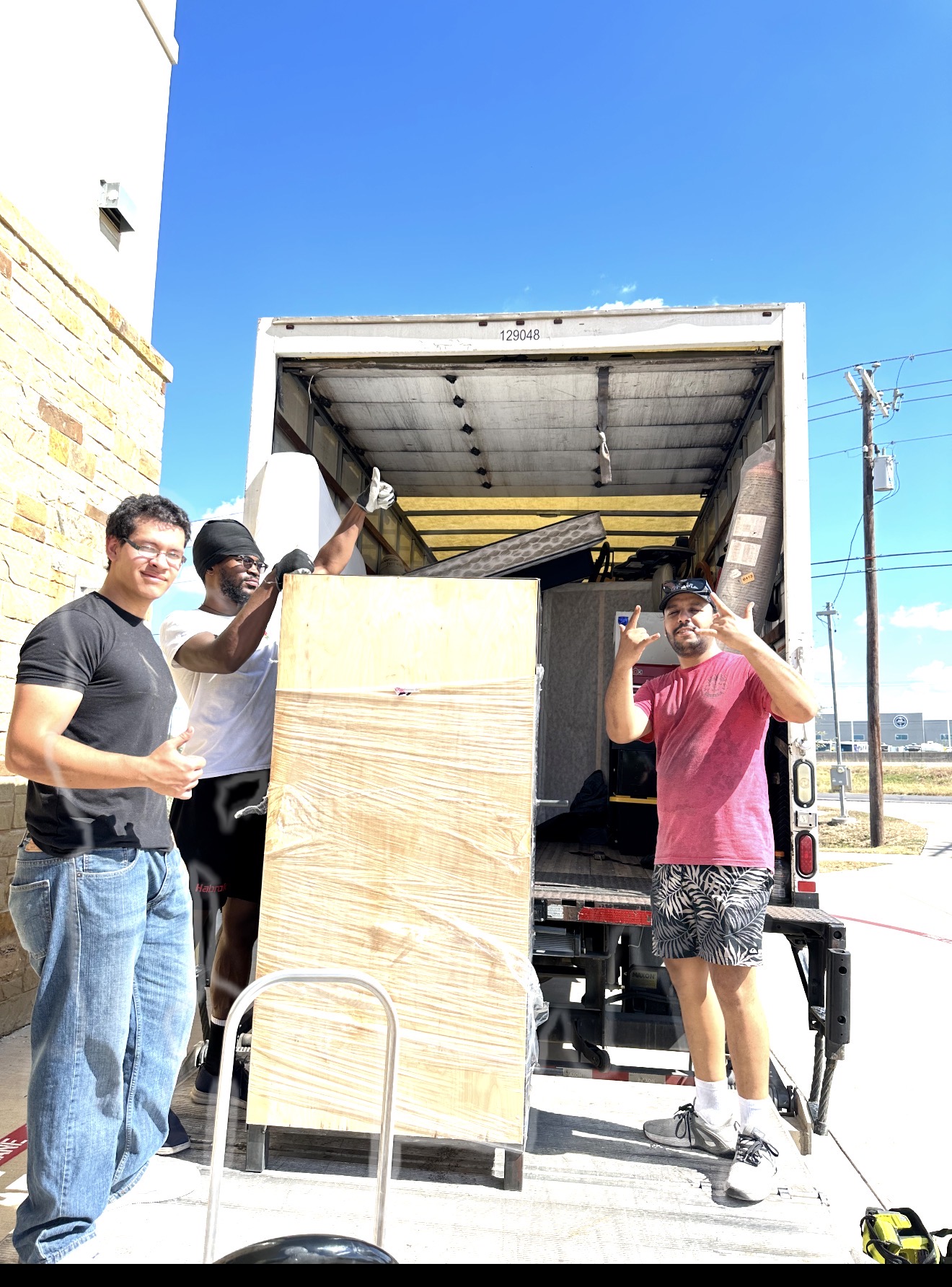 Kamal Dahaby and the Clean Moving crew on the liftgate of their truck in Austin